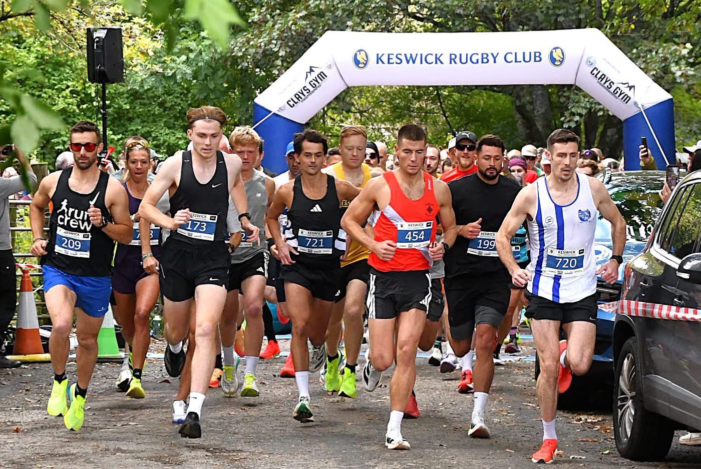 Runners setting off under the Keswick Rugby Club arch at the start of the Keswick Half Marathon